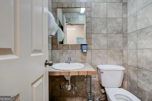 a bathroom with a toilet a sink and a mirror