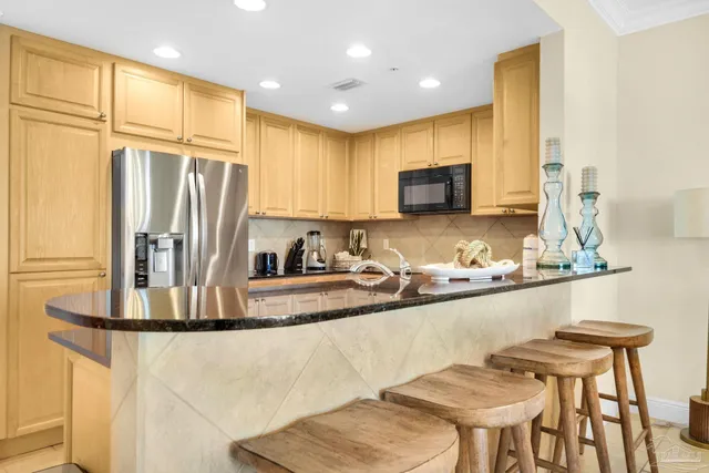 a kitchen with stainless steel appliances granite countertop a sink and a refrigerator
