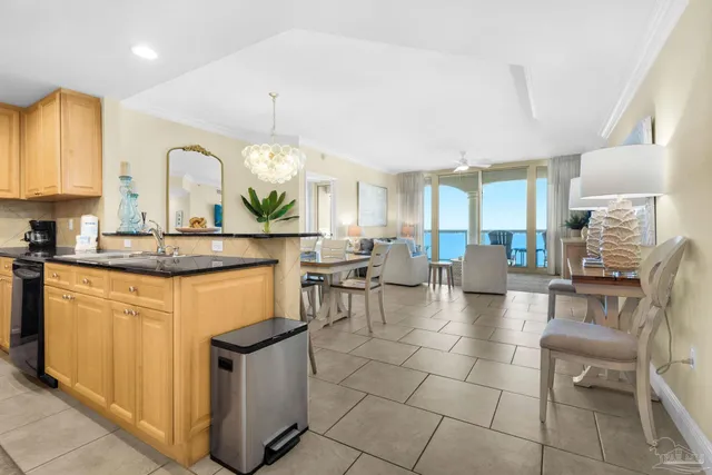 a kitchen with stainless steel appliances granite countertop a stove top oven a sink dishwasher and white cabinets next to a window