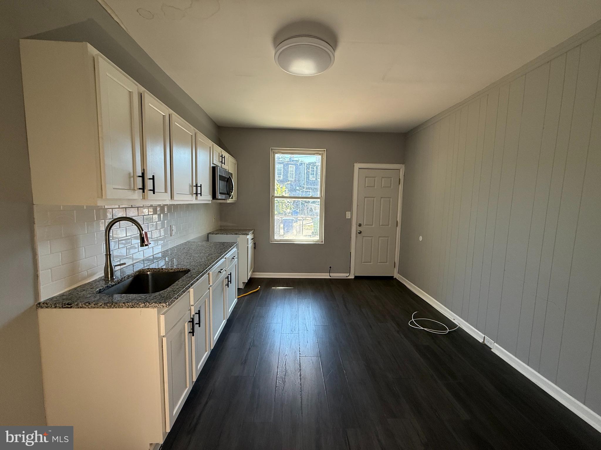 1635 Normal Avenue Baltimore, MD 21213 - Photo 5 of 18 an empty room with wooden floor and windows