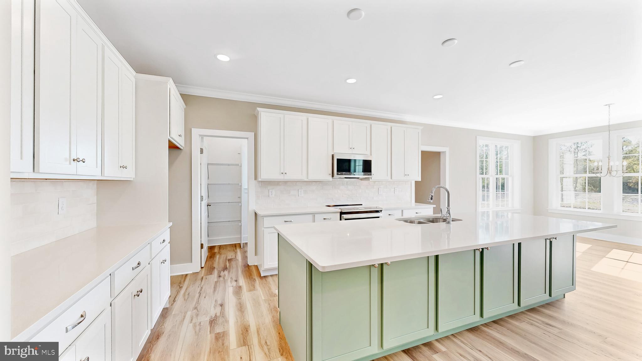 22012 Antlered Way Georgetown, DE 19947 - Photo 11 of 58 a kitchen with stainless steel appliances a stove top oven a refrigerator a sink and white cabinets with wooden floor