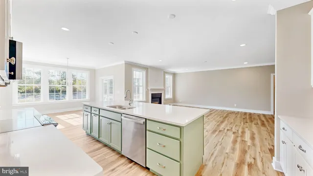a large white kitchen with a sink and large window