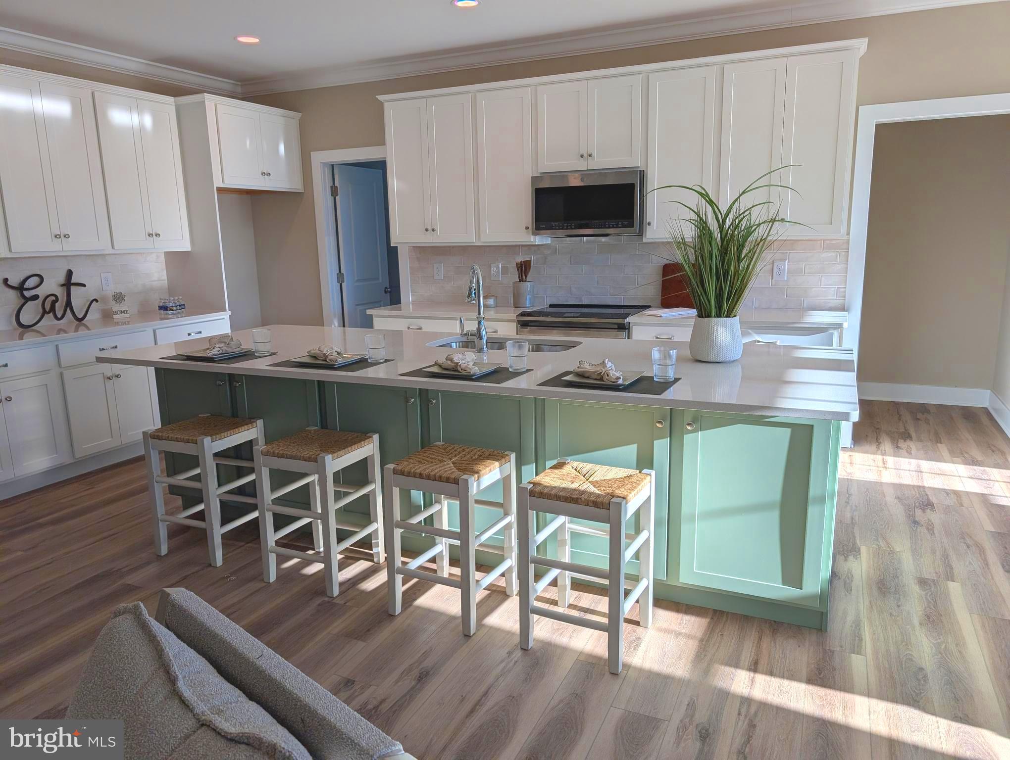 22012 Antlered Way Georgetown, DE 19947 - Photo 14 of 58 a kitchen with stainless steel appliances a dining table chairs and a refrigerator