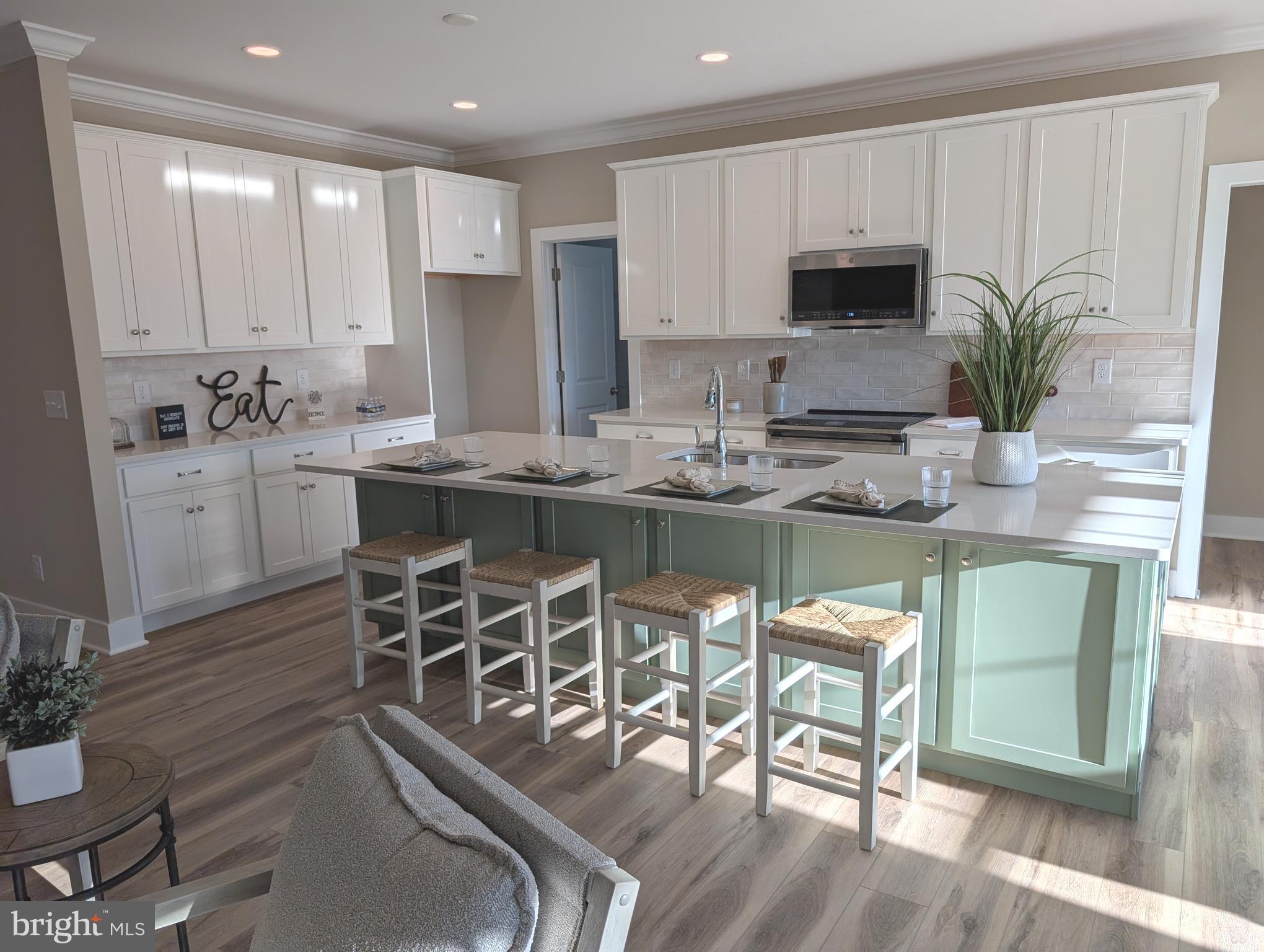 22012 Antlered Way Georgetown, DE 19947 - Photo 2 of 58 a kitchen with stainless steel appliances granite countertop table chairs sink and cabinets