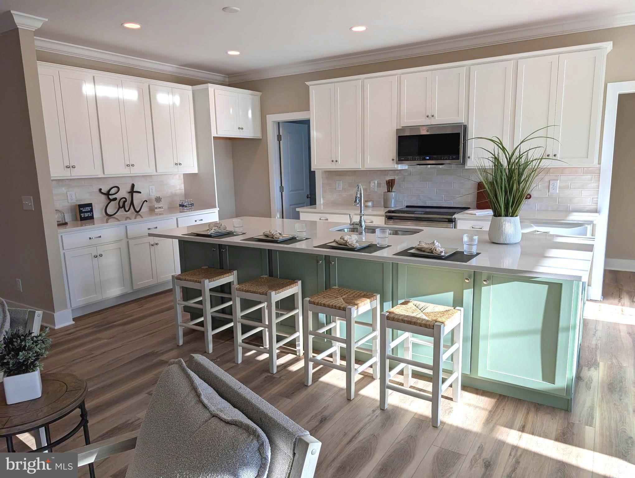 22012 Antlered Way Georgetown, DE 19947 - Photo 2 of 59 a kitchen with stainless steel appliances granite countertop table chairs sink and cabinets