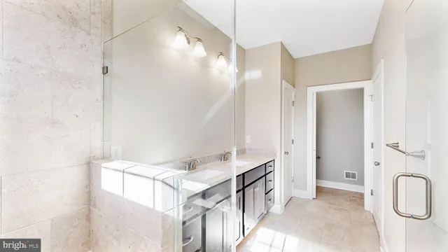 a view of a room with a sink and mirror