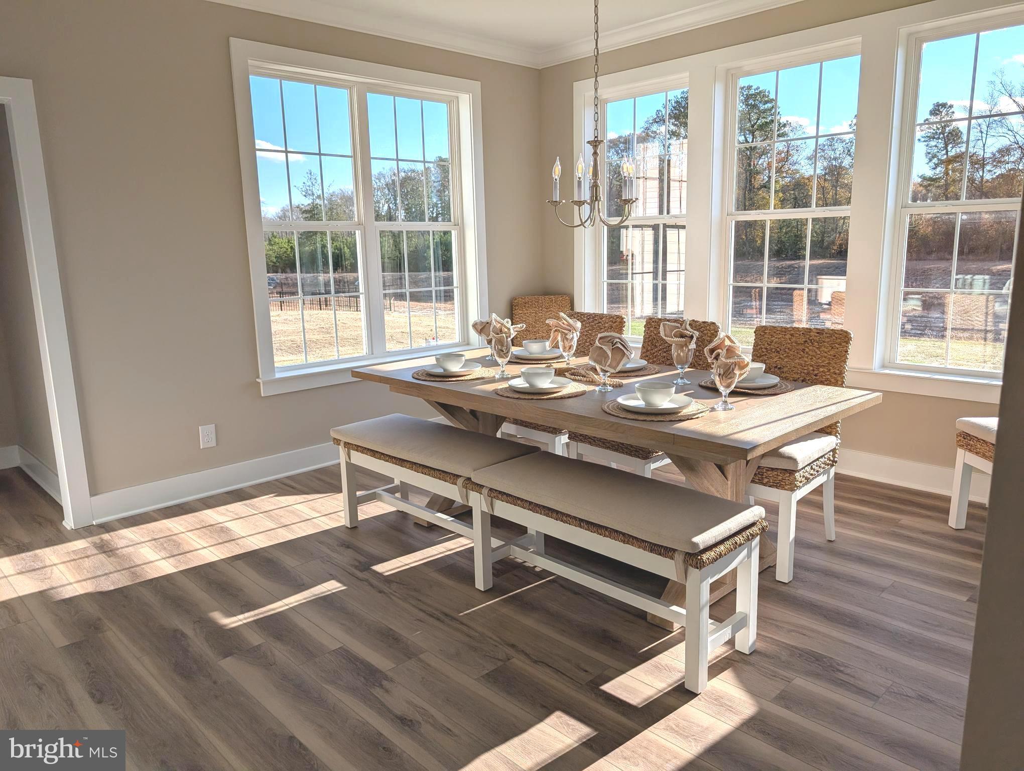 22012 Antlered Way Georgetown, DE 19947 - Photo 4 of 59 a view of a dining room with furniture large windows and wooden floor