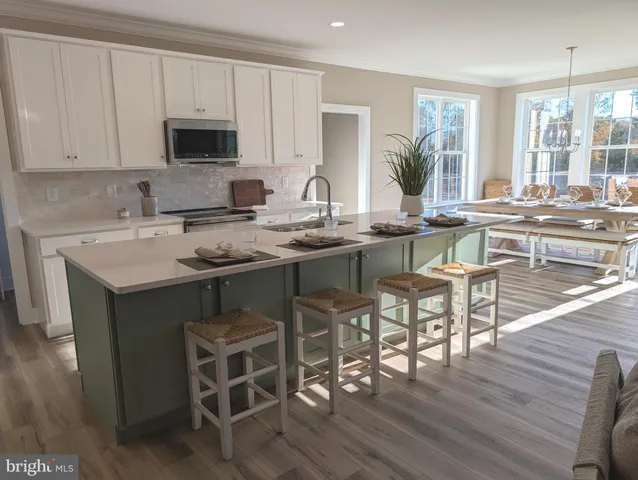 a kitchen with a dining table chairs and flat screen tv