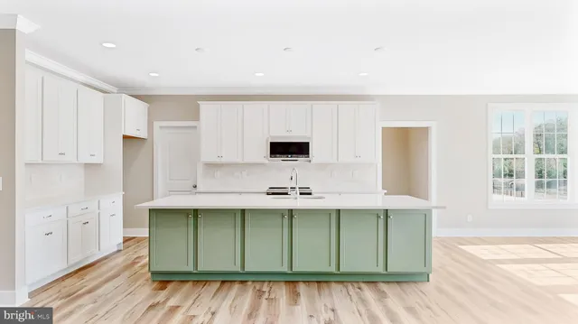 a kitchen with stainless steel appliances granite countertop a sink and cabinets with wooden floor