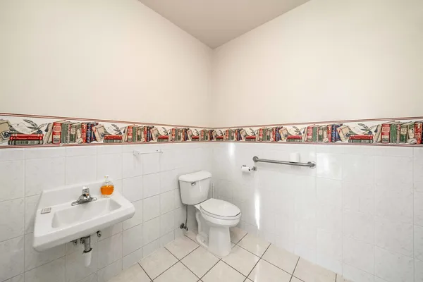 a white toilet sitting next to a white sink and vanity