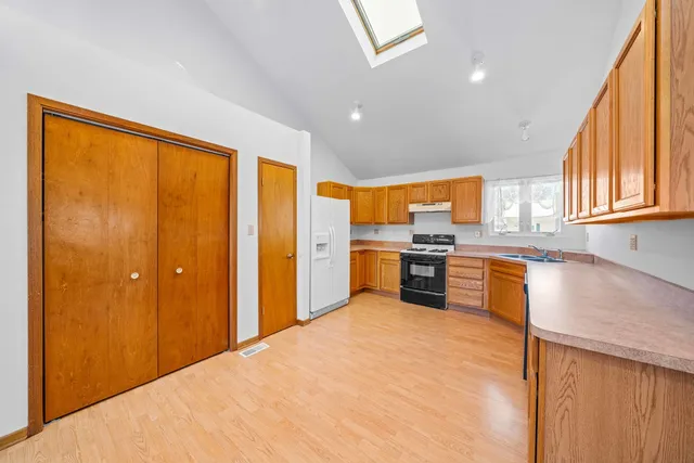 a kitchen with stainless steel appliances granite countertop a sink stove and refrigerator