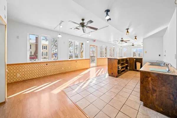 a large white kitchen with a large window and kitchen view