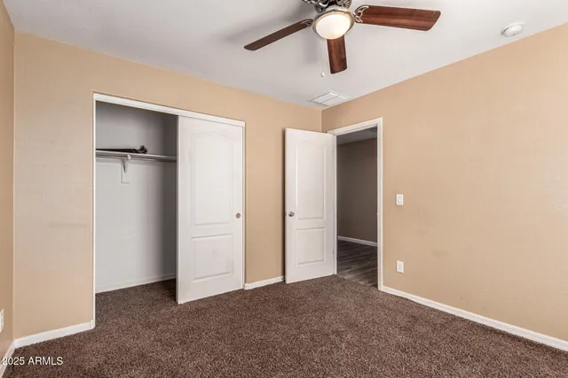 a view of an empty room with a ceiling fan