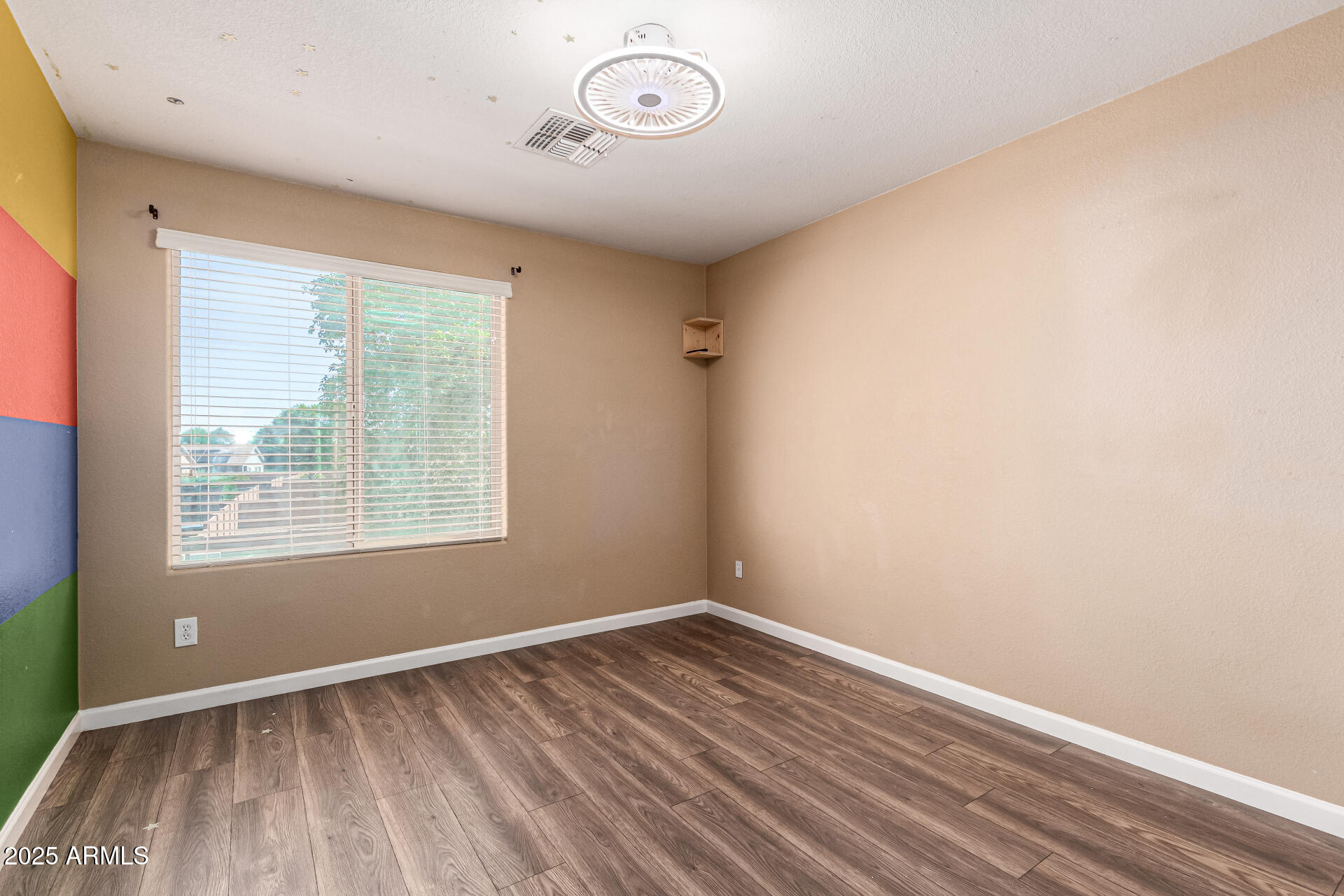 18586 North Lariat Road Maricopa, AZ 85138 - Photo 14 of 16 an empty room with wooden floor and windows