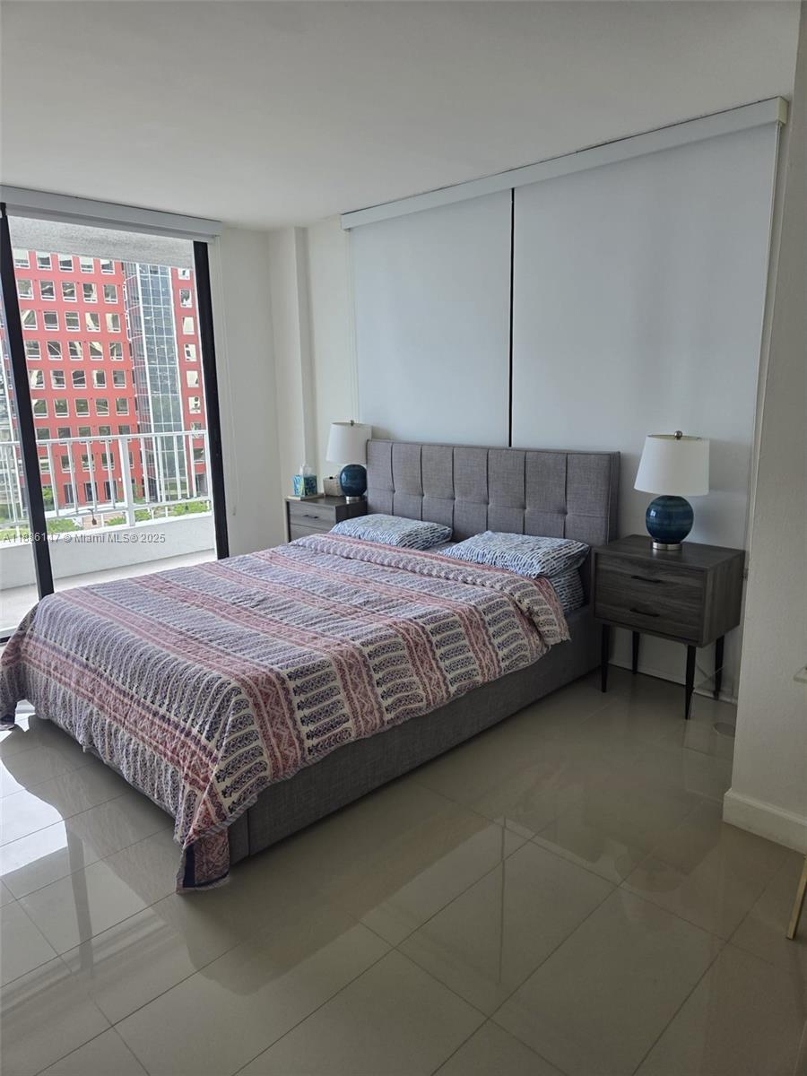 200 Southeast 15th Road, Unit 8J Miami, FL 33129 - Photo 14 of 20 a bedroom with a bed table and chair