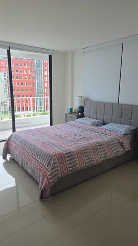 a bedroom with a large bed and a large window