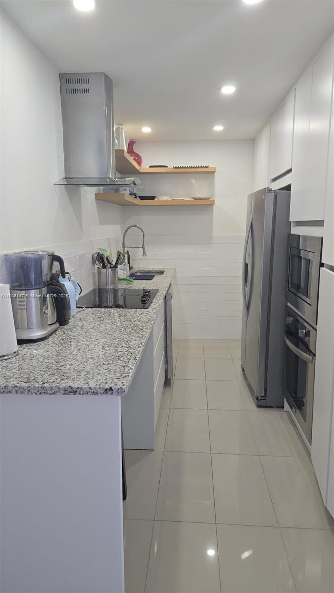 200 Southeast 15th Road, Unit 8J Miami, FL 33129 - Photo 5 of 20 a kitchen with stainless steel appliances granite countertop a sink a stove and a refrigerator