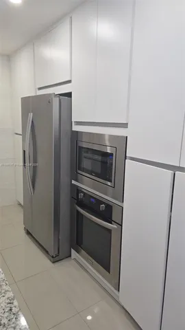 a metallic refrigerator freezer a stove sitting inside of a kitchen