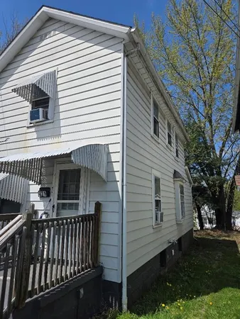 a view of house with backyard and trees