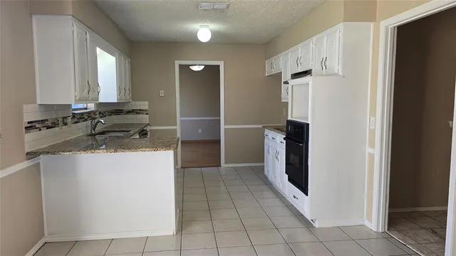 a kitchen with granite countertop a refrigerator and a sink