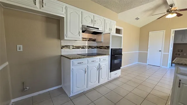a kitchen with stainless steel appliances granite countertop a refrigerator and a stove top oven