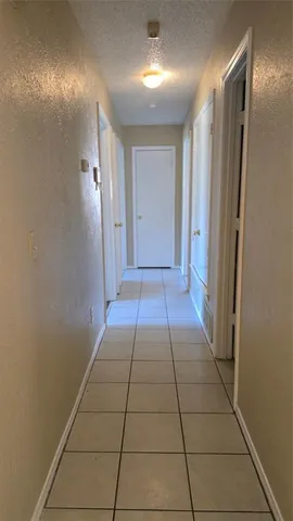 a view of hallway with a couch and a refrigerator