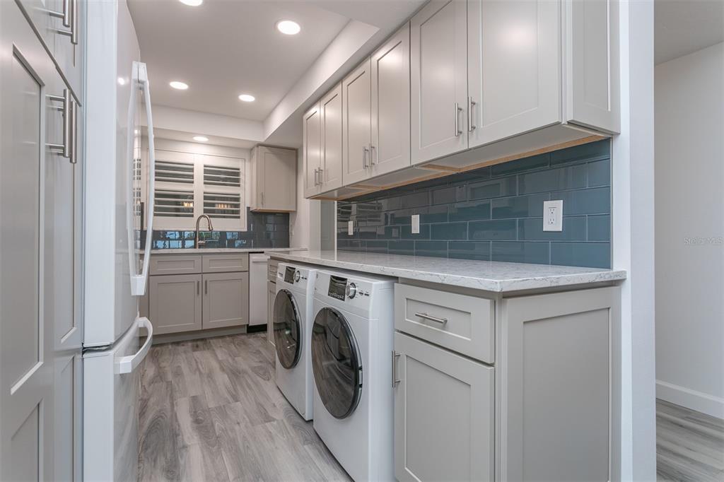633 Alhambra Road, Unit 305 Venice, FL 34285 - Photo 19 of 43 a utility room with cabinets washer and dryer