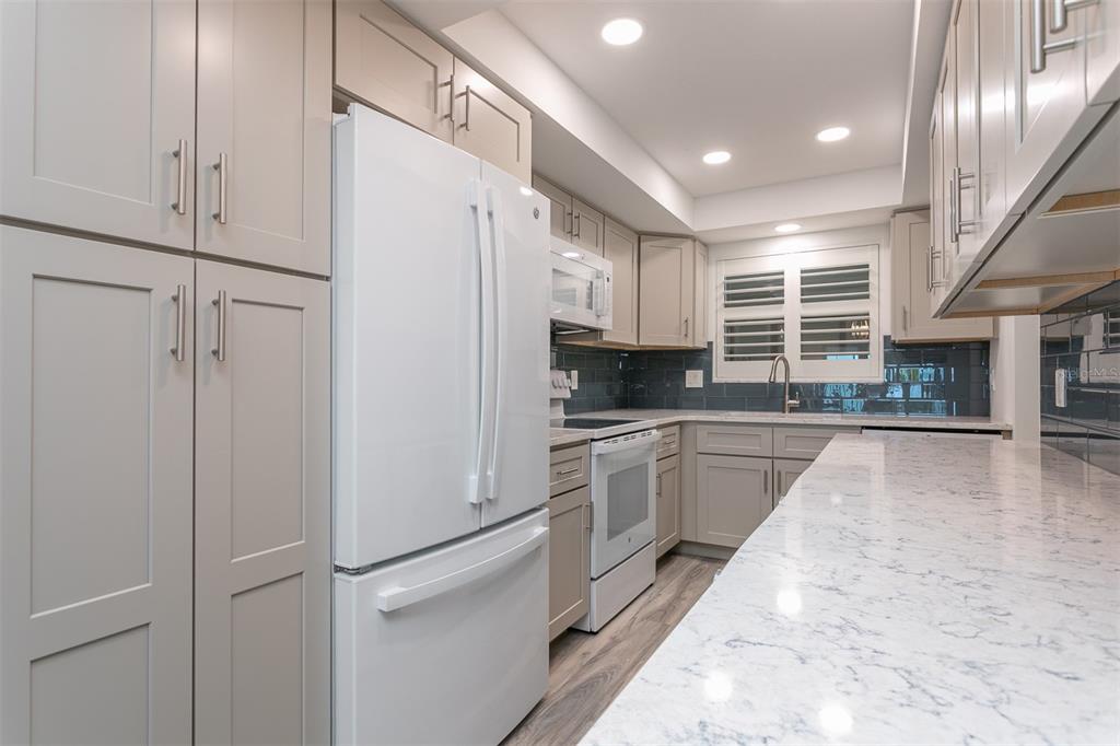 633 Alhambra Road, Unit 305 Venice, FL 34285 - Photo 20 of 43 a kitchen with granite countertop stainless steel appliances and white cabinets