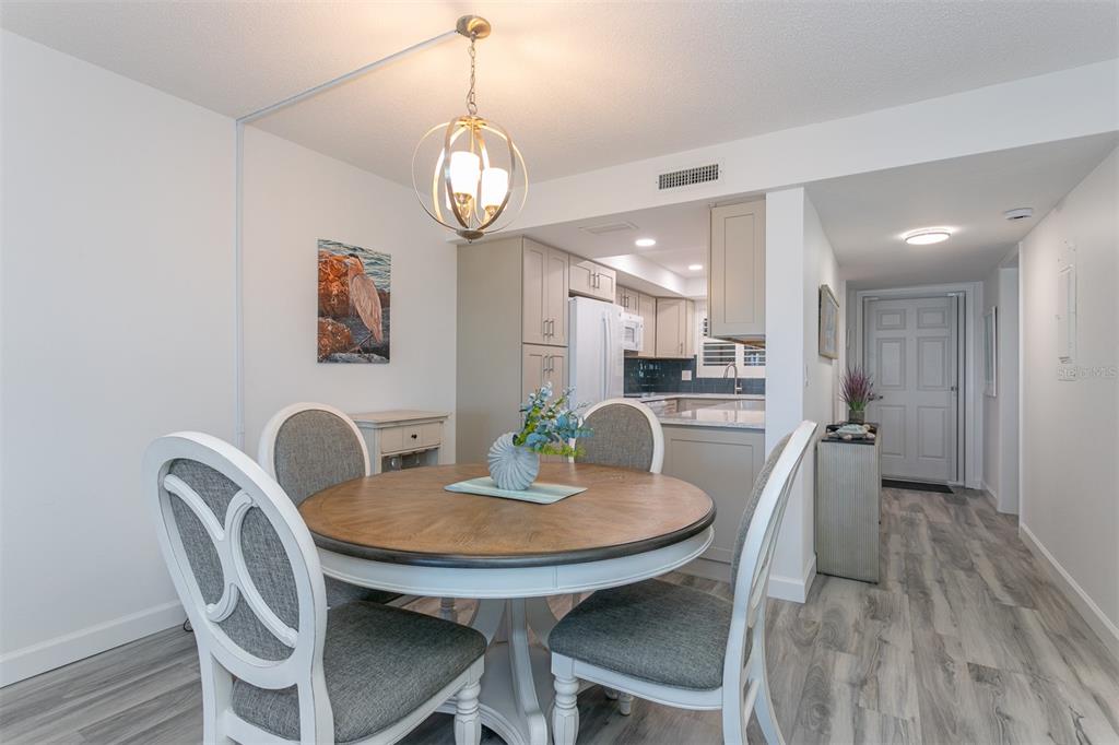 633 Alhambra Road, Unit 305 Venice, FL 34285 - Photo 24 of 43 a view of a dining room with furniture and wooden floor