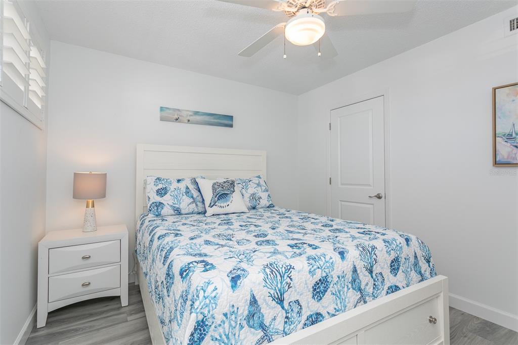 633 Alhambra Road, Unit 305 Venice, FL 34285 - Photo 36 of 43 a bedroom with a bed and a chandelier