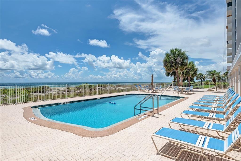633 Alhambra Road, Unit 305 Venice, FL 34285 - Photo 6 of 43 a view of a swimming pool with an outdoor seating and a yard