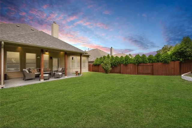 a front view of a house with a garden and trees
