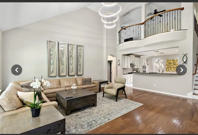 a living room with furniture wooden floor and wall paintings