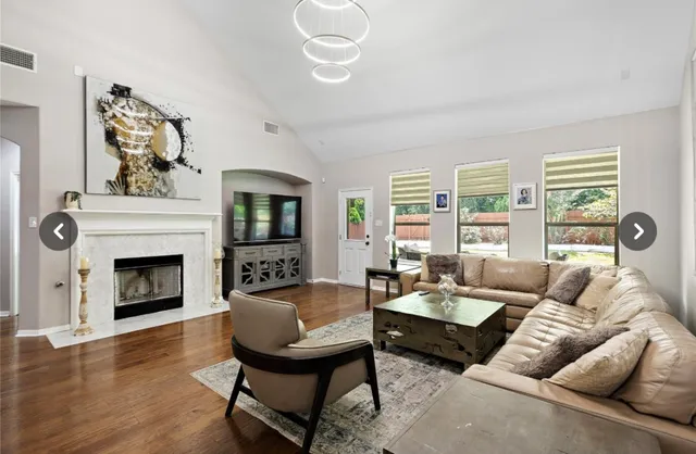 a living room with furniture a fireplace and a large window