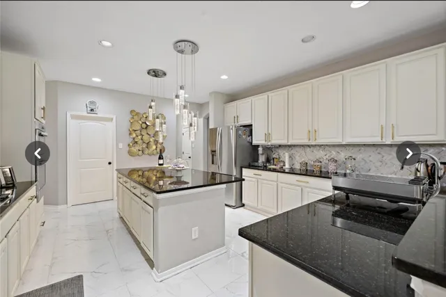 a kitchen with granite countertop a sink a stove and refrigerator