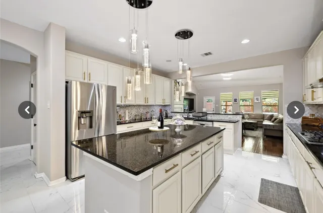 a kitchen with stainless steel appliances granite countertop a sink a stove and a refrigerator