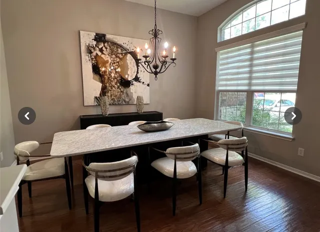 a view of a dining room with furniture a chandelier and wooden floor