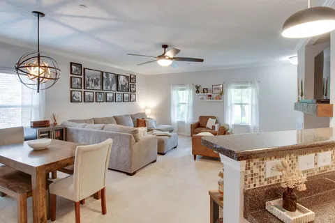 a living room with furniture a chandelier and a window