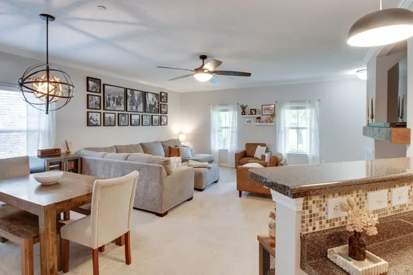 a living room with furniture a chandelier and a window