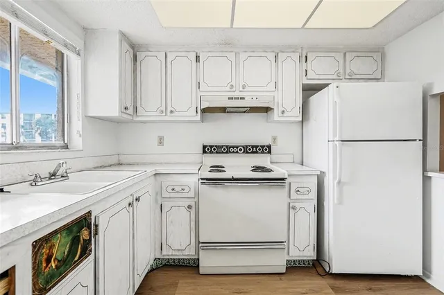 a kitchen with appliances a sink and cabinets