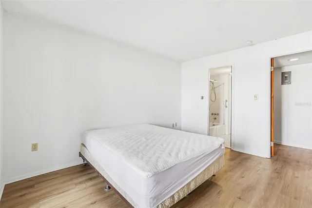 a bedroom with a bed and wooden floor