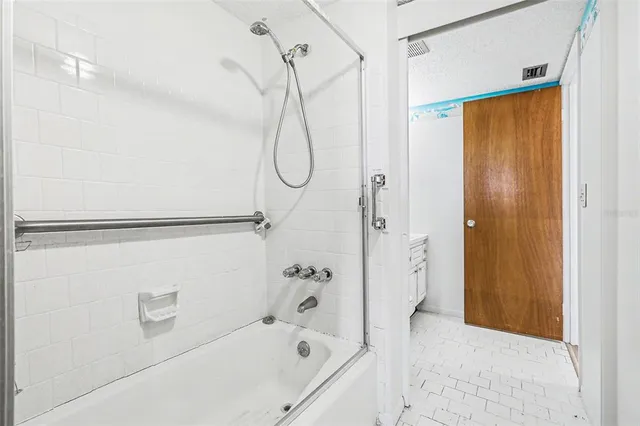 a bathroom with a bath tub with a shower