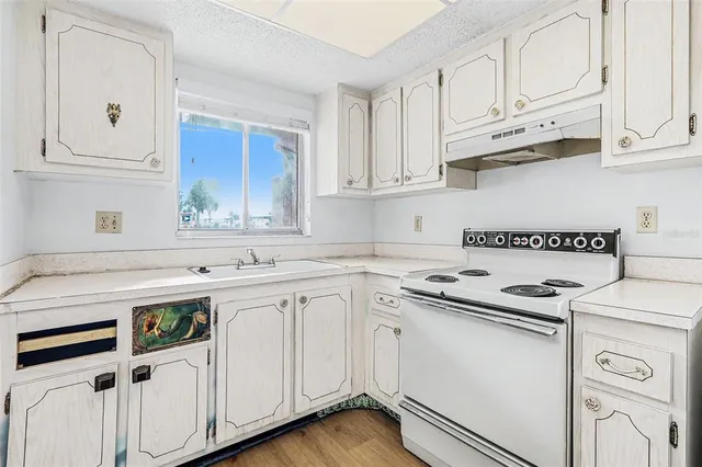 a kitchen with stainless steel appliances granite countertop white cabinets and a sink