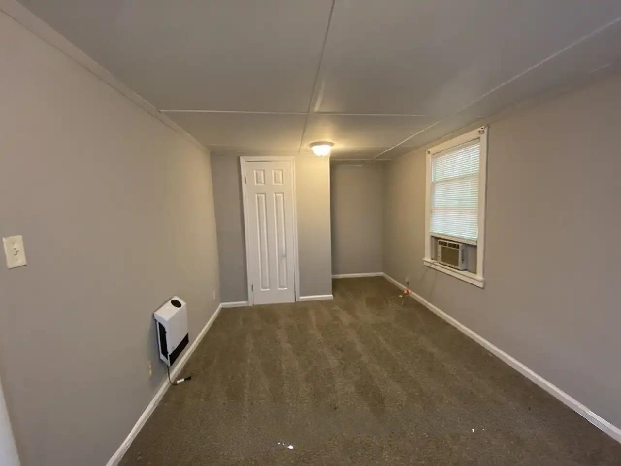 494 East Raines Road Memphis, TN 38109 - Photo 4 of 9 Unfurnished room featuring heating unit, cooling unit, and carpet flooring