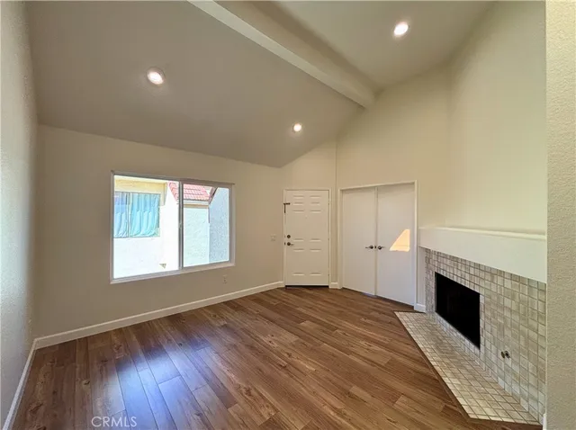 a view of empty room with wooden floor and fireplace