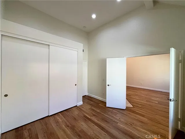 an empty room with wooden floor and white doors