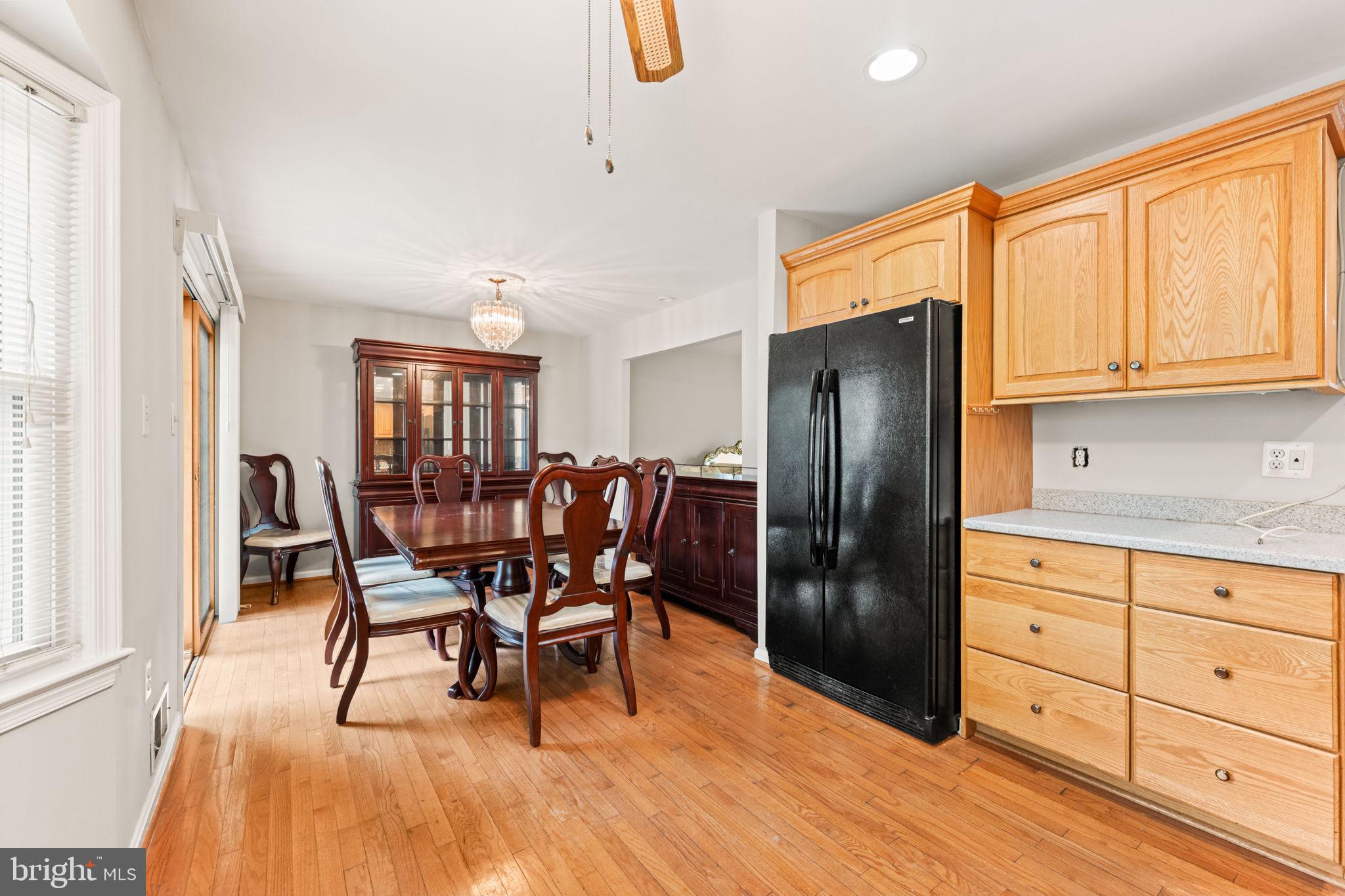 8000 Lady Lewis Court Springfield, VA 22153 - Photo 15 of 44 a kitchen with stainless steel appliances granite countertop a refrigerator a stove a dining table and chairs with wooden floor