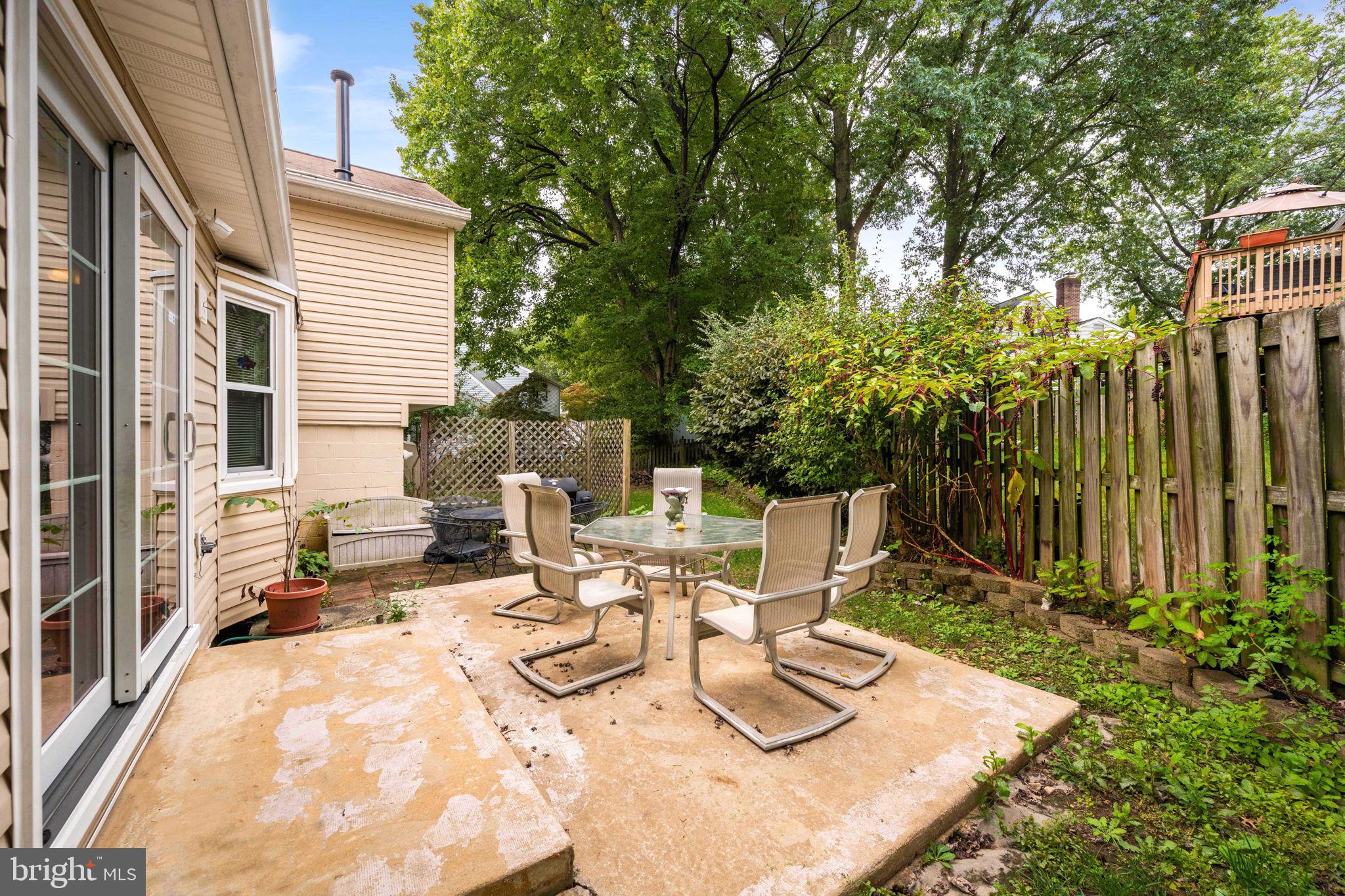 8000 Lady Lewis Court Springfield, VA 22153 - Photo 36 of 44 a view of a patio with table and chairs and potted plants with wooden floor and fence