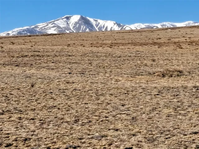 a view of a large building with mountains in the background