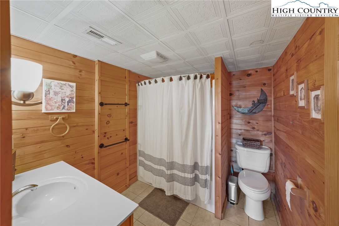 196 Eagle Nest Road Purlear, NC 28665 - Photo 28 of 36 a bathroom with a granite countertop toilet a sink and shower